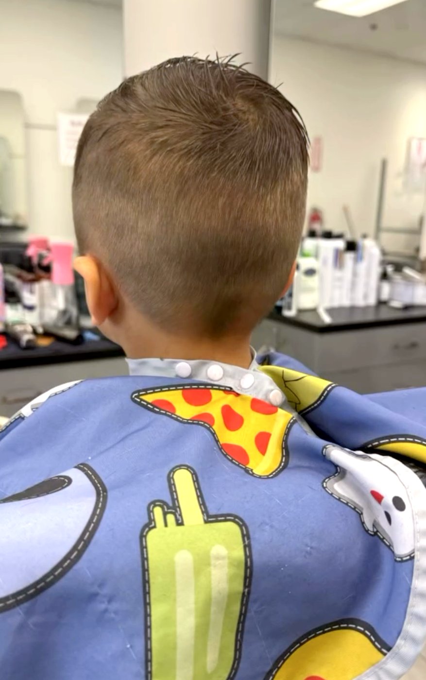 A young boy’s fresh short haircut.
