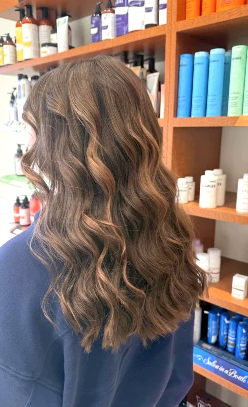 Brunette hair with caramel balayage and loose waves.